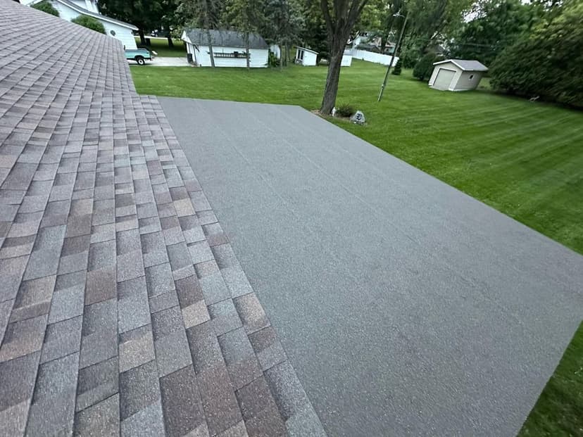 Roof area featuring new shingles and a textured surface on a residential property.